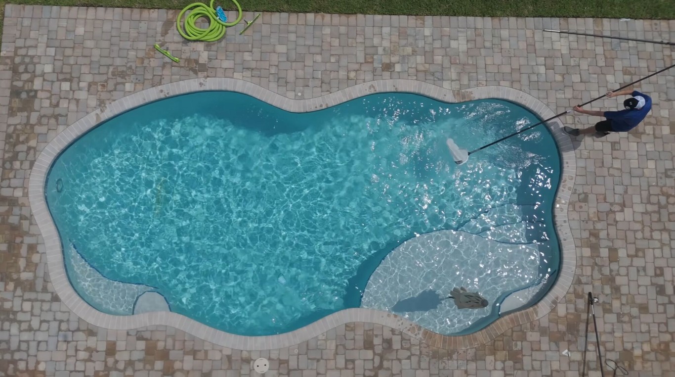 Aerial view of pool being cleaned by technician in Cibolo, TX